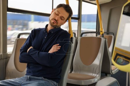 Foto de Hombre cansado durmiendo sentado en el transporte público - Imagen libre de derechos
