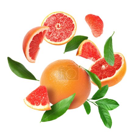 Photo for Cut fresh grapefruits and green leaves flying on white background - Royalty Free Image