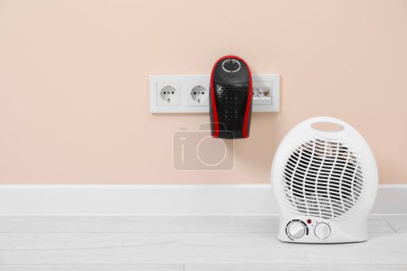 Photo for Modern electric compact and fan heaters indoors, space for text - Royalty Free Image