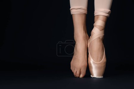 Photo for Ballerina in pointe shoe dancing on black background, closeup. Space for text - Royalty Free Image