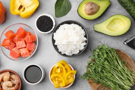 Ingredients for poke bowl on grey table, flat lay