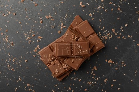 Téléchargez les photos : Morceaux de chocolat savoureux sur table grise, vue sur le dessus - en image libre de droit