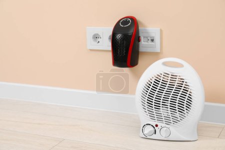 Photo for Modern electric compact and fan heaters indoors, space for text - Royalty Free Image