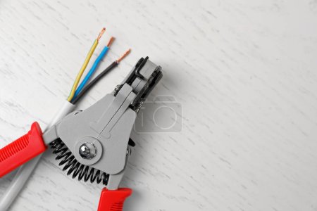 Photo for Professional cutters and wire on white wooden table, flat lay. Space for text - Royalty Free Image