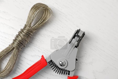 Photo for Professional cutters and wire on white wooden table, flat lay - Royalty Free Image
