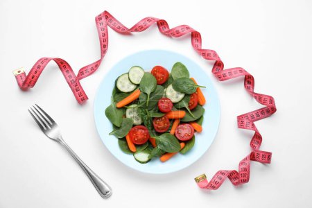 Maßband, Salat und Gabel auf weißem Hintergrund, flach gelegt