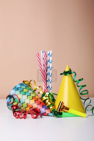 Foto de Sombreros de fiesta coloridos, serpentinas y pajitas en la mesa blanca. Celebración del cumpleaños - Imagen libre de derechos