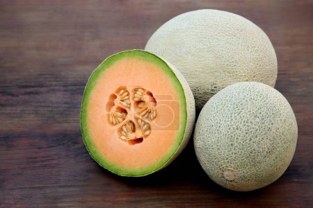 Photo for Whole and cut fresh ripe melons on wooden table - Royalty Free Image
