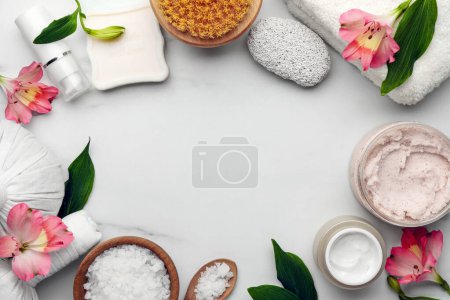 Foto de Marco hecho de diferentes productos cosméticos sobre mesa de mármol blanco, plano y espacio para el texto. Composición del spa - Imagen libre de derechos