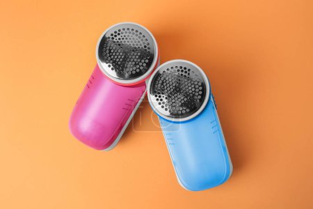Photo for Modern fabric shavers on pale orange background, flat lay - Royalty Free Image