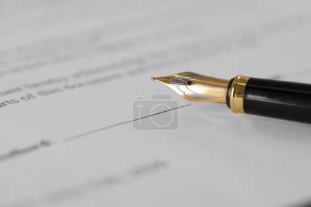 Fountain pen on document with place for signature, closeup and space for text. Notary contract