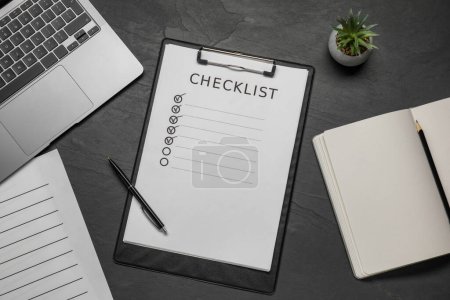 Photo for Clipboard with checklist, pen and laptop on black table, flat lay - Royalty Free Image