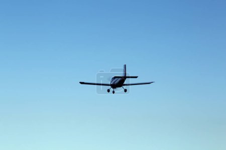 Modern ultralight airplane flying in blue sky