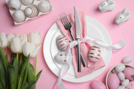 Photo for Festive table setting with painted eggs and tulips on pink background, flat lay. Easter celebration - Royalty Free Image