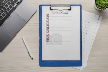 Téléchargez les photos : Presse-papiers avec check-list, stylo et ordinateur portable sur table en bois, plan plat - en image libre de droit