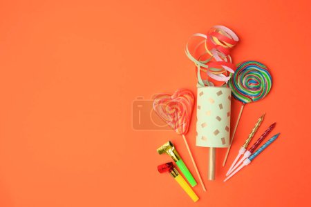 Photo for Party cracker and different festive items on orange background, flat lay. Space for text - Royalty Free Image