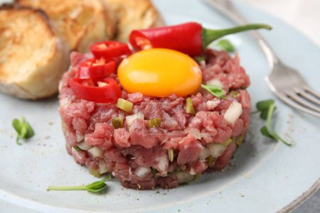 Photo for Tasty beef steak tartare served with yolk and other accompaniments on plate, closeup - Royalty Free Image