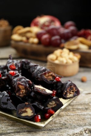 Foto de Bandeja con deliciosas churchkhelas dulces sobre mesa de madera, primer plano - Imagen libre de derechos