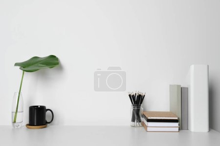 Téléchargez les photos : Lieu de travail confortable avec bureau blanc près du mur. Espace pour le texte - en image libre de droit