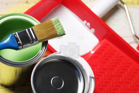 Photo for Cans of paints, brush and tray on table, closeup - Royalty Free Image