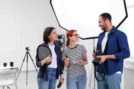 Téléchargez les photos : Jeunes photographes professionnels travaillant dans un studio photo moderne, espace pour le texte - en image libre de droit
