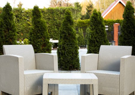 Téléchargez les photos : Fauteuils confortables et table basse dans la cour arrière. Beaux meubles de jardin en rotin - en image libre de droit