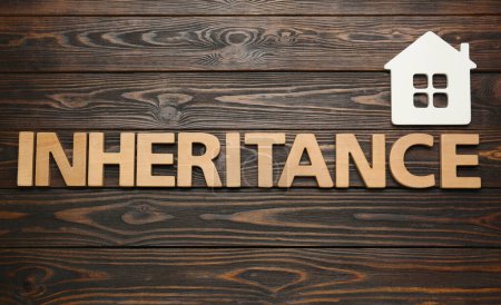 Photo for Word Inheritance made with letters and house model on wooden background, flat lay - Royalty Free Image