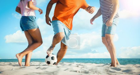 Foto de Amigos jugando al fútbol en la playa durante el día soleado, primer plano. Diseño de banner - Imagen libre de derechos