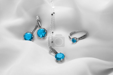 Piękna biżuteria z jasnoniebieskimi kamieniami na białym materiale