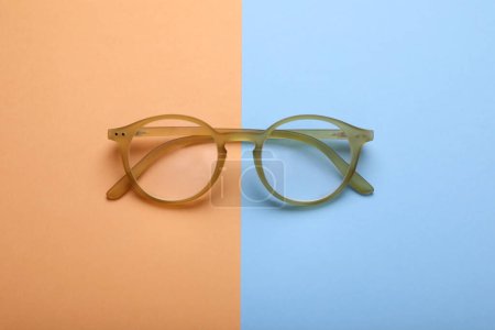 Foto de Gafas con lentes correctoras sobre fondo de color, vista superior - Imagen libre de derechos