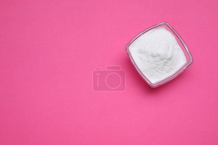 Foto de Cuenco de fructosa dulce en polvo sobre fondo rosa, vista superior. Espacio para texto - Imagen libre de derechos