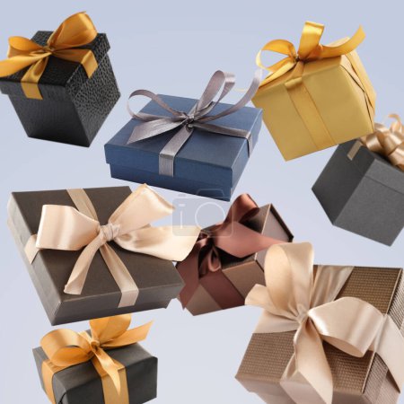 Many beautiful gift boxes falling on pale light blue background