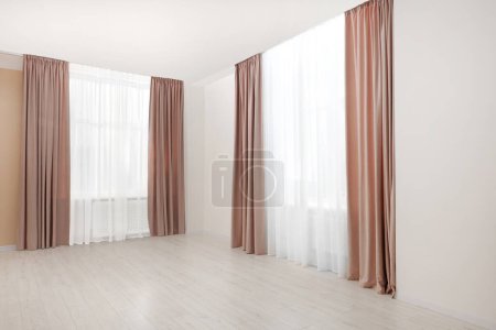 Foto de Elegantes cortinas de ventana y tul blanco en el interior. Diseño de interiores - Imagen libre de derechos
