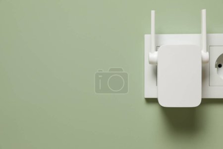 Photo for Wireless Wi-Fi repeater on light green wall, space for text - Royalty Free Image