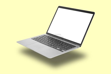 Photo for Modern laptop flying on pale light yellow background - Royalty Free Image