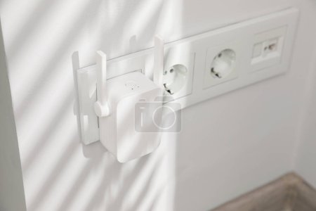 Photo for Wireless Wi-Fi repeater on white wall indoors - Royalty Free Image