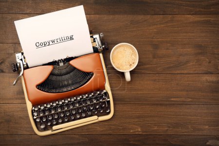 Word Copywriting typed on paper. Typewriter and cup of coffee on wooden table, flat lay. Space for text