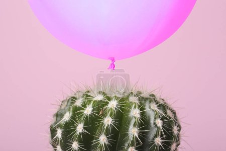 Photo for Violet balloon over cactus on pink background - Royalty Free Image