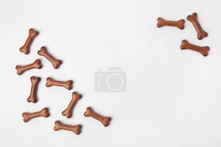 Téléchargez les photos : Biscuits pour chien en forme d'os sur fond blanc, plat. Espace pour le texte - en image libre de droit