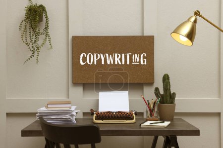 Photo for Cork board with word Copywriting, typewriter, plants and stationery in stylish room - Royalty Free Image