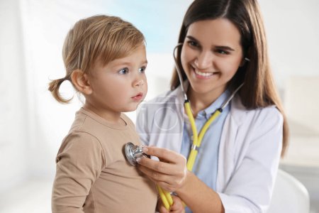 Photo for Pediatrician examining baby with stethoscope in clinic - Royalty Free Image