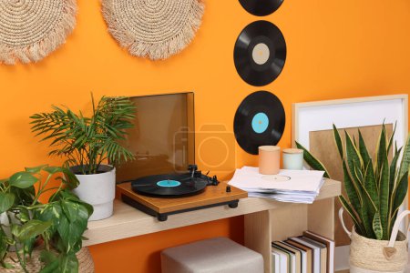 Téléchargez les photos : Plaque tournante élégante avec disque vinyle sur la table de console dans une pièce confortable - en image libre de droit