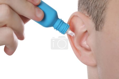 Homme utilisant des gouttes d'oreille sur fond blanc, gros plan