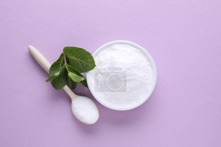 Sweet powdered fructose and mint leaves on light purple background, flat lay