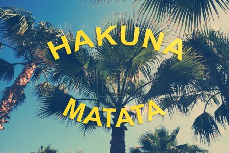 Foto de Hakuna Matata, frase inspiradora en swahili que significa sin preocupaciones. Palmeras al aire libre en el soleado día de verano, tonificación de color estilizado - Imagen libre de derechos
