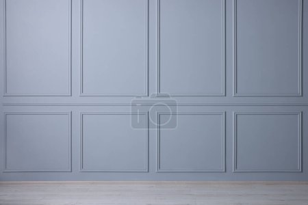 Chambre vide avec mur bleu clair et plancher en bois