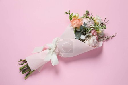 Bouquet of beautiful flowers on pink background, top view
