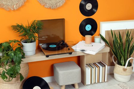 Téléchargez les photos : Plaque tournante élégante avec disque vinyle sur la table de console dans une pièce confortable - en image libre de droit