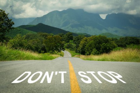 Photo for Motivational phrase. Words Don't Stop written on empty road leading to mountains - Royalty Free Image