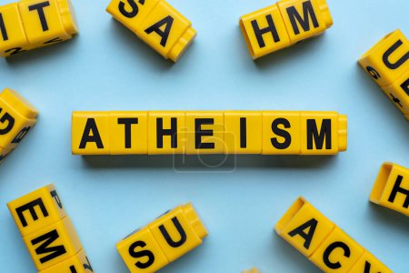 Photo for Word Atheism made of yellow cubes with letters on light blue background, flat lay - Royalty Free Image